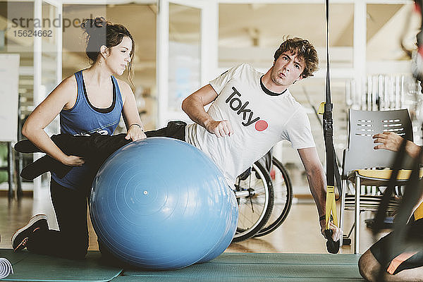 Mittlerer Erwachsener  der während einer Physiotherapie-Sitzung mit Hanteln übt