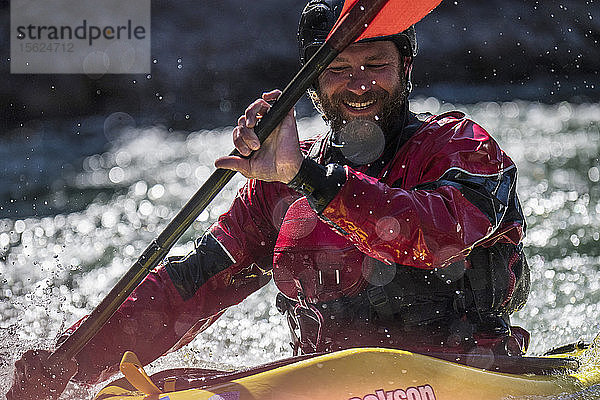 Nahaufnahme eines lächelnden männlichen Kajakfahrers beim Kajakfahren auf dem Snake River  Jackson Hole  Wyoming  USA