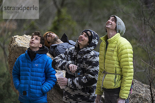 Vier Männer schauen nach oben und beobachten Kletterer  Siurana  Katalonien  Spanien