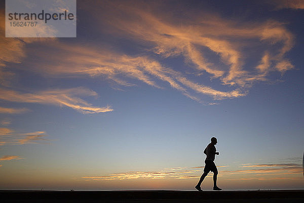 Eine Person joggt bei Sonnenuntergang am Windansea Beach im Stadtteil La Jolla von San Diego  Kalifornien.