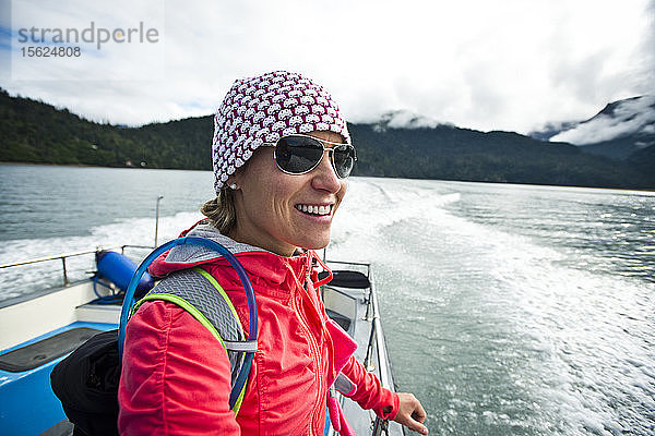 Ein Mädchen in Abenteuerkleidung auf dem Rücken eines Bootes in der Nähe von Homer  Alaska.
