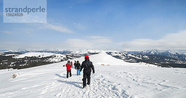 Gruppe von Menschen wandern einen schneebedeckten Berg hinunter zu Motorschlitten  Vail  Colorado