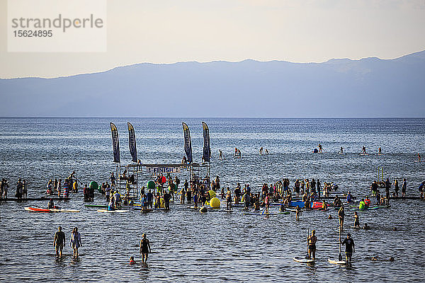 Menschen versammeln sich bei der SUP-Rennserie am El Dorado Beach in South Lake Tahoe.