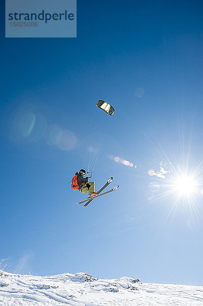 Totale Aufnahme eines Mannes in der Luft beim Snowkiten