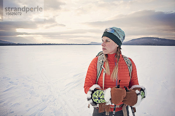 Eine Skilangläuferin posiert für ein Porträt auf dem zugefrorenen Flagstaff Lake  Maine.