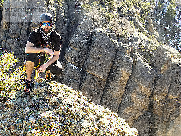 Ein Mann erklimmt den Heart Rock  einen Berg im Maple Canyon  und füllt das Gipfelbuch aus  das auf dem Gipfel aufbewahrt wird.