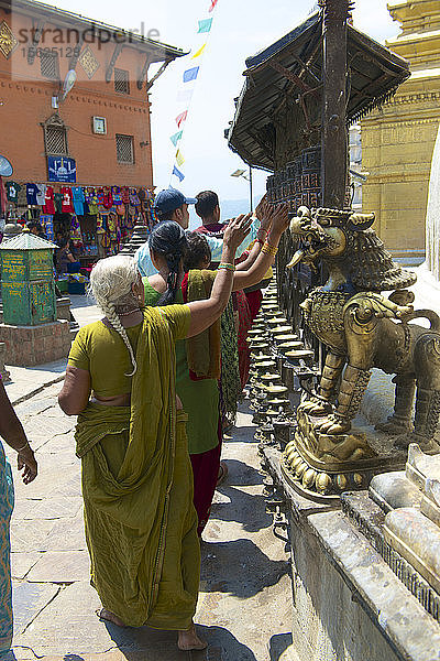 Pilger beim Drehen buddhistischer Gebetsmühlen im Swayambhunath-Tempel