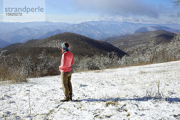 Ein Wanderer  der auf dem Appalachian Trail unterwegs ist  macht eine Pause  um die Aussicht entlang des Appalachian Trail zu genießen. Schnee ist in den Bergen von GA im März keine Seltenheit.