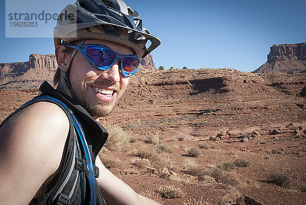 Freunde erkunden die Wüste Utahs im Herbst bei einem ausgedehnten Mountainbike-Abenteuer auf dem White Rim Trail im Canyonlands National Park bei Moab  Utah.