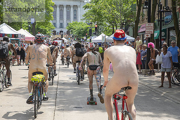 Eine große Anzahl nackter Radfahrer fährt auf der Straße  um gegen die Abhängigkeit von fossilen Brennstoffen zu protestieren  Madison  Wisconsin  USA