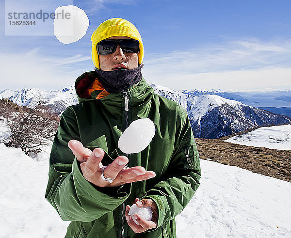 Ein Snowboarder jongliert Schneebälle an einem sonnigen Tag am Cerro Catedral in Argentinien