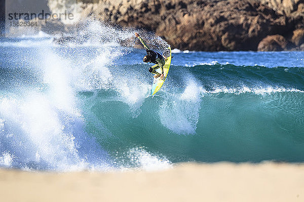 Ein Surfer macht einen Luftsprung über die Lippe einer blauen Welle in Doni?ï¿½os  Nordspanien