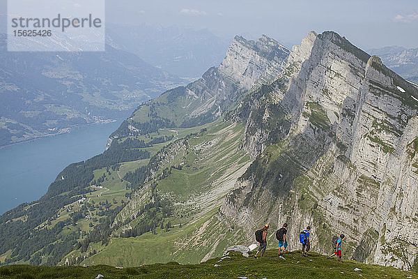 Eine Gruppe von Basejumpern wandert in den Alpen oberhalb des Wallener Sees  um ihren nächsten Flugplatz zu finden. Toggenburg  Schweiz