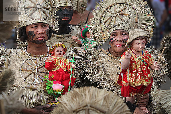 Frauen in Stammeskostümen halten Santo Nino-Figuren beim Ati Atihan-Festival  Kalibo  Aklan  Insel Panay  Philippinen