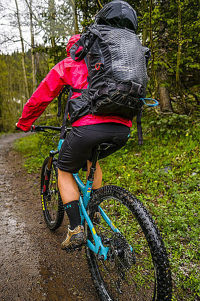 Rückansicht einer Radfahrerin  die den Ice Lakes Trail bei Regen überquert  Colorado  USA