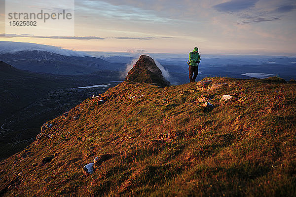 Ein Wanderer und Fotograf wandert auf dem Gipfel des Berges Suilven in Schottland  Vereinigtes Königreich.