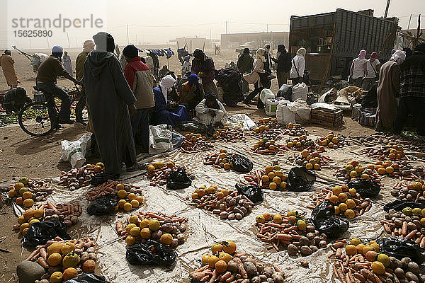 staubige Sandstraße in der Kasbah von M'hamid im Süden Marokkos. Markt  auf dem Karotten  Kartoffeln und Zwiebeln verkauft werden