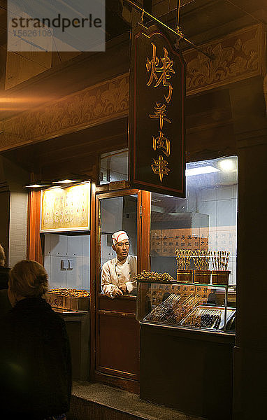Verkäuferin mit Kochmütze im Lebensmittelgeschäft auf dem Nachtmarkt  Peking  China
