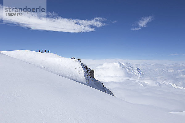 Bergsteiger wandern über einen Schneekamm zum Rand der Welt  der sich in der Nähe des Hochlagers am Denali in Alaska befindet.