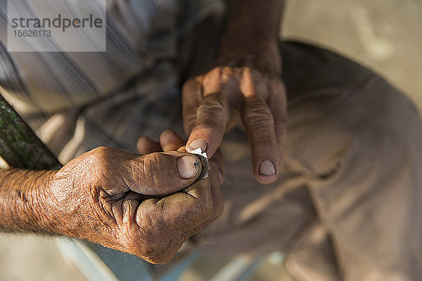 Nahaufnahme eines Mannes  der seine Fingernägel mit einer Rasierklinge reinigt  Vinales  Provinz Pinar del Rio  Kuba