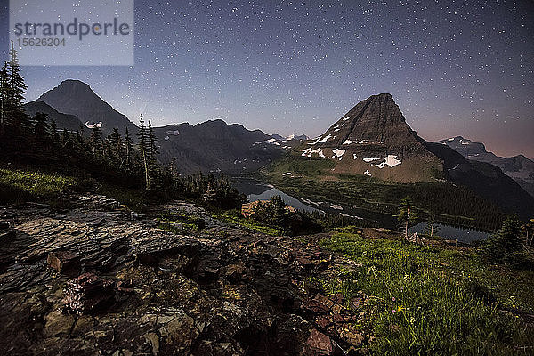 Eine Mondsichel erweckt die unglaubliche Landschaft um den Hidden Lake im Glacier National Park zum Leben.