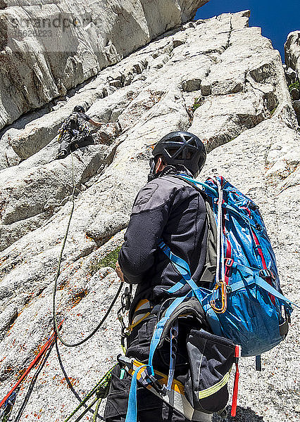 Mann betrachtet seinen Freund beim Klettern auf dem Felsen in den Wasatch Mountains  Utah