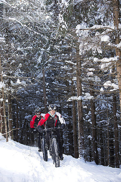 Profi-Biker aus den Rocky Mountains beim Wintertraining auf einem Fat Bike auf einem Bergpfad in Quebec  Kanada