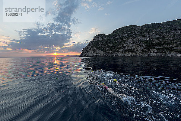 Eine Gruppe von Schwimmern Schwimmen im Mittelmeer bei Sonnenuntergang