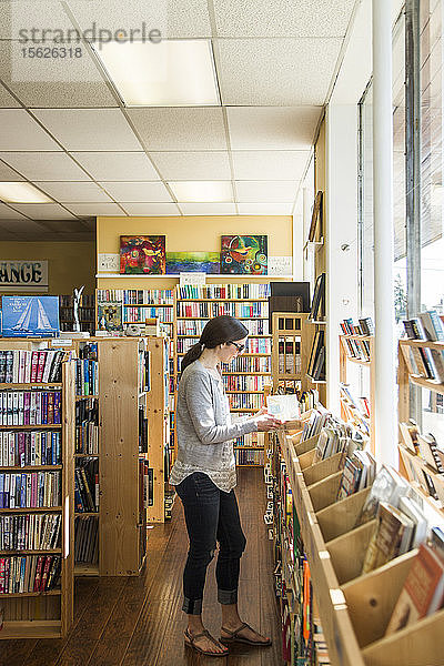 Junge Frau liest ein Buch in einer Buchhandlung  Seattle  Washington  USA
