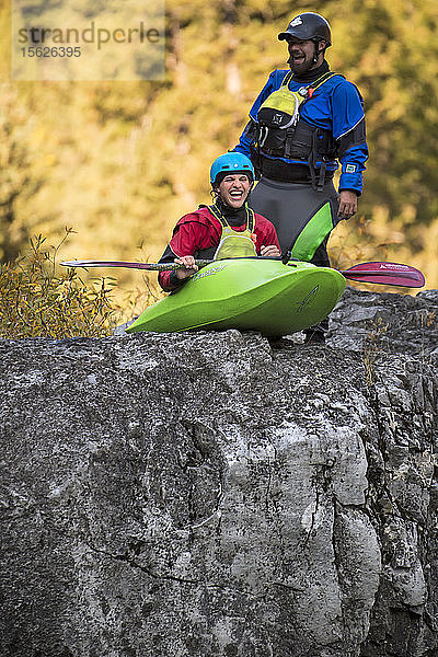 Kajakfahrer lacht  während er sich darauf vorbereitet  von der Spitze eines Felsens in den Fluss zu springen  Jackson Hole  Wyoming  USA