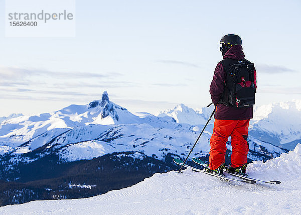 Ein einsamer Skifahrer steht auf einem Grat und blickt in die Ferne auf den legendären Black Tusk in Whistler Blackcomb