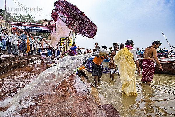 Ein Arbeiter reinigt die Steinstufen  die in den Ganges führen  am Dr. Rajendra Prasad Ghat  Varanasi  Uttar Pradesh  Indien