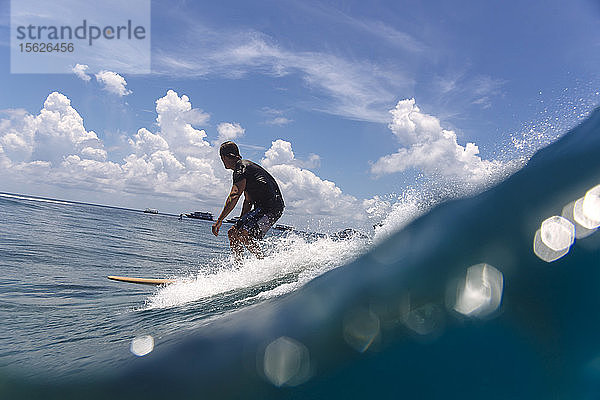 Male-Surfer reitet auf einer Welle gegen die Wolken  Male  Malediven