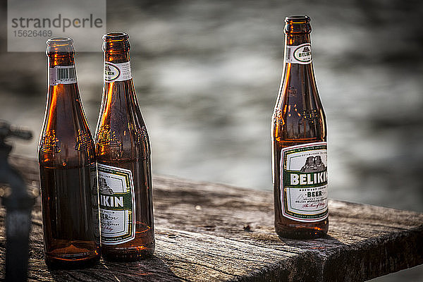 Belikin-Bierflaschen auf einem Steg am Wasser