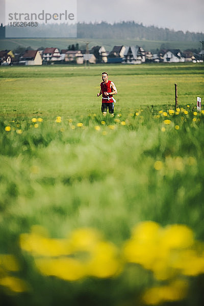 Fernansicht eines einzelnen Mannes beim Joggen auf einer Wiese  Zaskale  Woiwodschaft Malopolskie  Polen