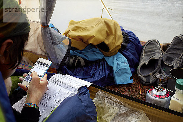 Eine Wanderin auf dem Appalachian Trail macht sich in ihrem Zelt Notizen über ihre Reise  während sie darauf wartet  dass der morgendliche Regen nachlässt.