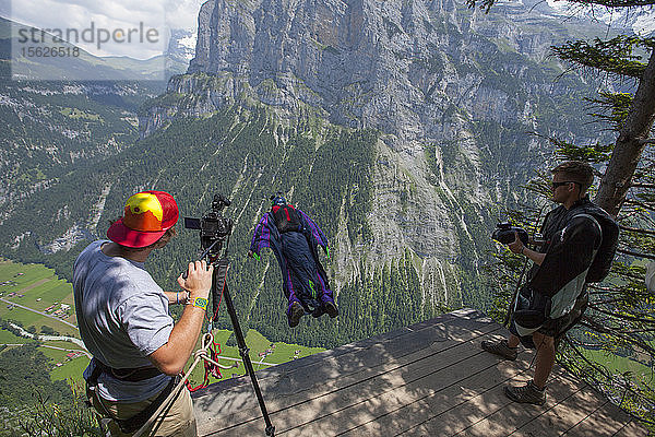 Videofilmer Tyler Lee filmt Wingsuit-BASE-Springer am Ausstiegspunkt des Klettersteigs im Lauterbrunnental in der Schweiz.