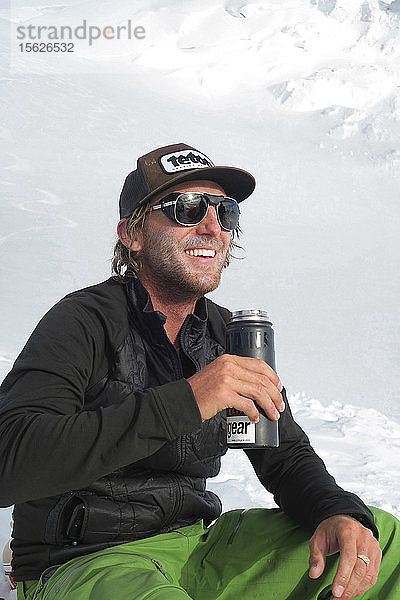 Ein glücklicher Bergsteiger genießt einen kurzen Moment des sonnigen und warmen Wetters hoch oben auf dem Denali
