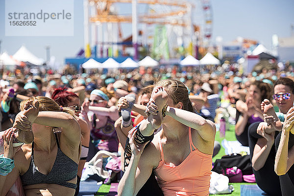 Menschen in fortgeschrittenen Posen während des Yoga-Festivals im Freien am Santa Monica Pier in Santa Monica  Kalifornien  USA