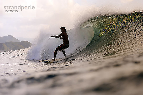 Silhouette eines Surfers auf einer Welle im Meer