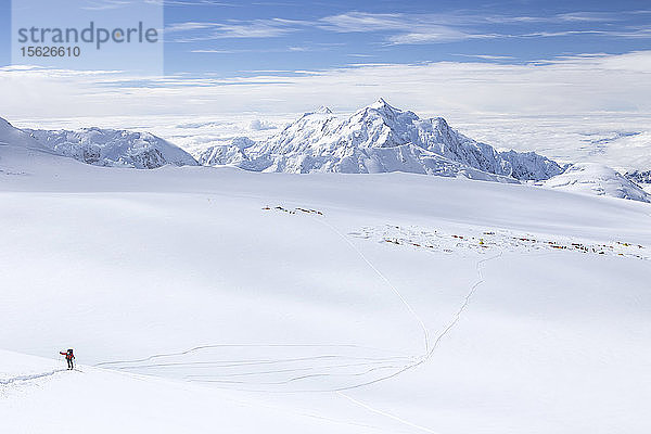 Ein Skitourengeher auf dem Weg zum Denali in Alaska  mit dem 14.000-Fuß-Lager im Hintergrund.