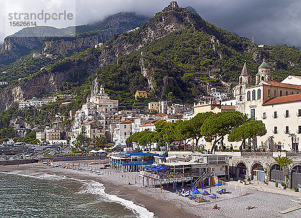 Die an der Bucht von Salerno gelegene Klippenstadt Amalfi verfügt über eine beliebte Strandpromenade. Amalfi ist eine Stadt und Gemeinde in der Provinz Salerno  in der Region Kampanien  Italien  am Golf von Salerno. Sie liegt an der Mündung einer tiefen Schlucht  am Fuße des Monte Cerreto (1.315 Meter)  umgeben von dramatischen Klippen und Küstenlandschaften. Die Stadt Amalfi war die Hauptstadt der Seerepublik Herzogtum Amalfi  einer wichtigen Handelsmacht im Mittelmeerraum zwischen 839 und etwa 1200. In den 1920er und 1930er Jahren war Amalfi ein beliebtes Urlaubsziel für die britische Oberschicht und Aristokratie. Amalfi ist der Hauptort der Küste  die Costiera Amalfitana (Amalfiküste) genannt wird  und ist heute zusammen mit anderen Orten an derselben Küste wie Positano  Ravello und anderen ein wichtiges Touristenziel. Amalfi ist Teil des UNESCO-Weltkulturerbes.