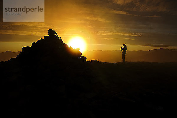 Silhouette eines Wanderers  Fotograf auf dem Gipfel des Berges Suilven in Schottland  Vereinigtes Königreich.