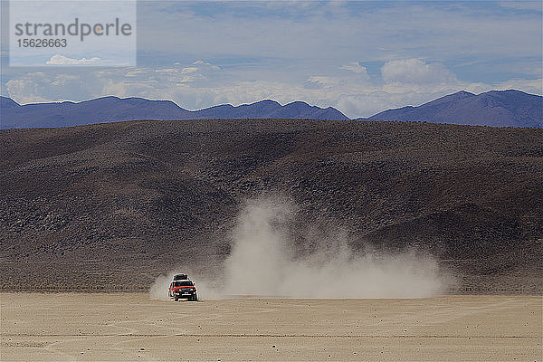 Auto hinterlässt Staubspur in der Wüste