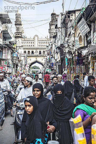 Burkha-Frauen gehen an belebten Straßen und einem Markt in der Nähe des Char Minar in Hyderabad  Indien  vorbei