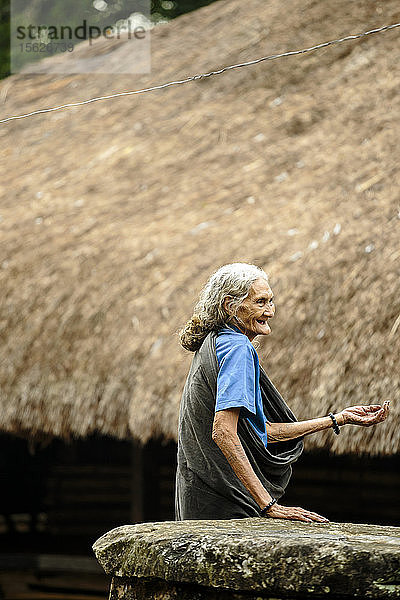 Porträt einer lächelnden älteren Frau vor einem traditionellen Haus  Sumba  Indonesien