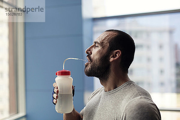 Muskulöser Mann trinkt Wasser