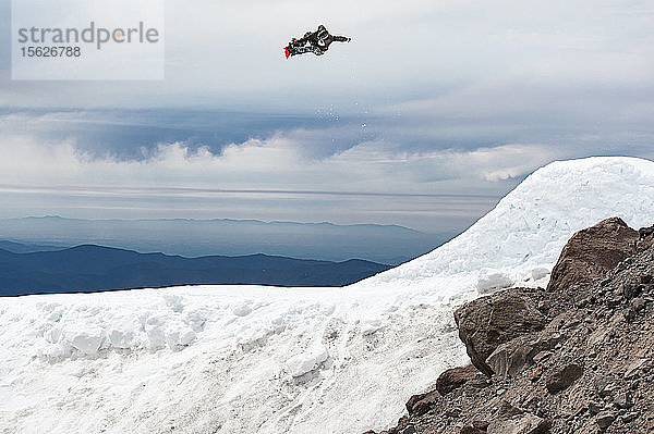 Ein Snowboarder springt im Sommer von einer großen Schanze am Mt. Hood