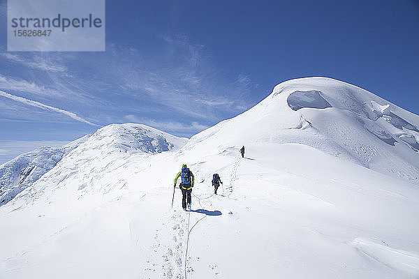 Bergsteiger auf dem Weg zum Gipfel des Kahiltna Dome  einem Berg in der Nähe des Denali in Alaska. Die Bergsteiger sind mit einem Seil verbunden  um sie vor dem Absturz in eine Gletscherspalte zu schützen. Der Denali-Nationalpark ist ein großartiger Ort für Skitouren und Bergsteiger-Touren im Hinterland.