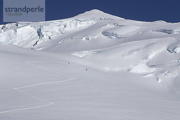 Bergsteiger fahren auf 12.000 Fuß Höhe am Denali in Alaska einen Hang hinunter.